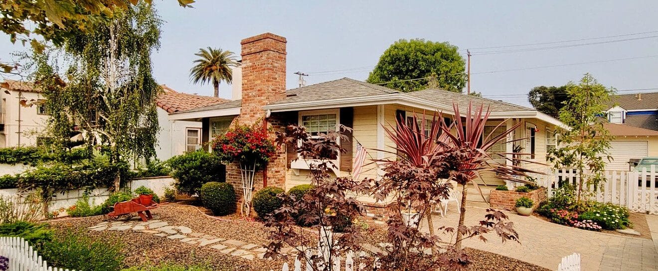 A single-story ranch home with a brick chimney in Santa Maria